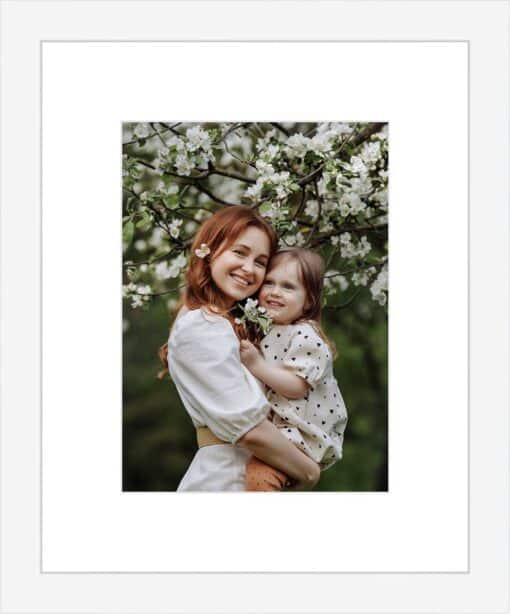 Framed photo of a mother and daughter embracing under a blooming tree.